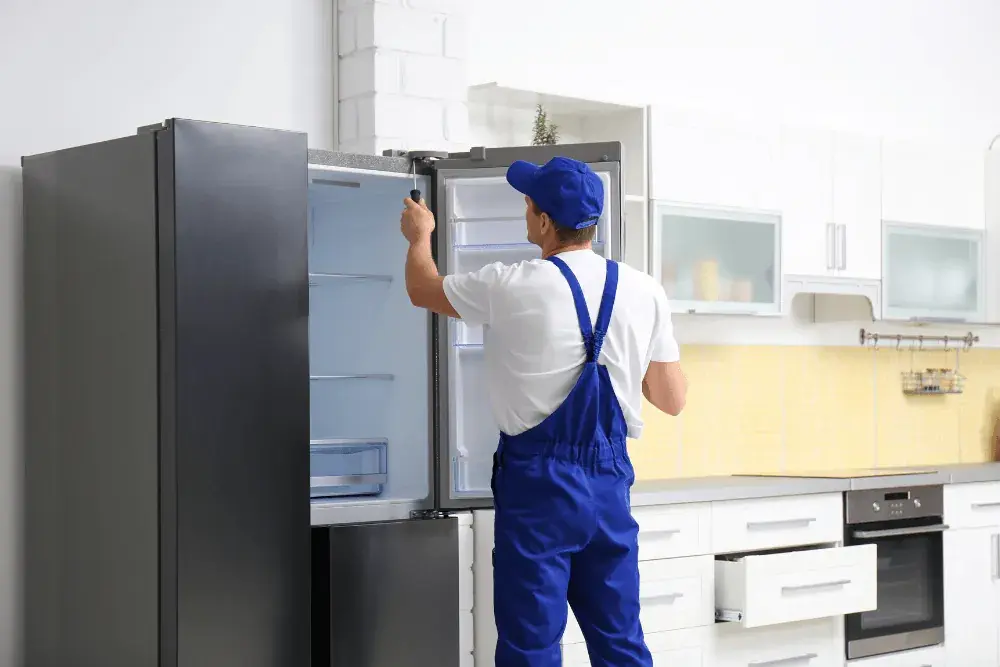 Technician repairing a refrigerator